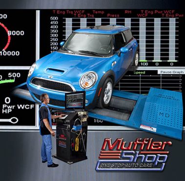 A man in front in front of a computer and blue car